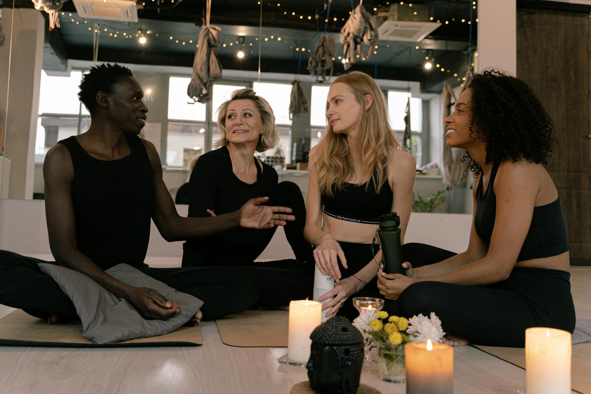 A diverse group of adults engaged in relaxation and meditation in a cozy yoga studio setting.